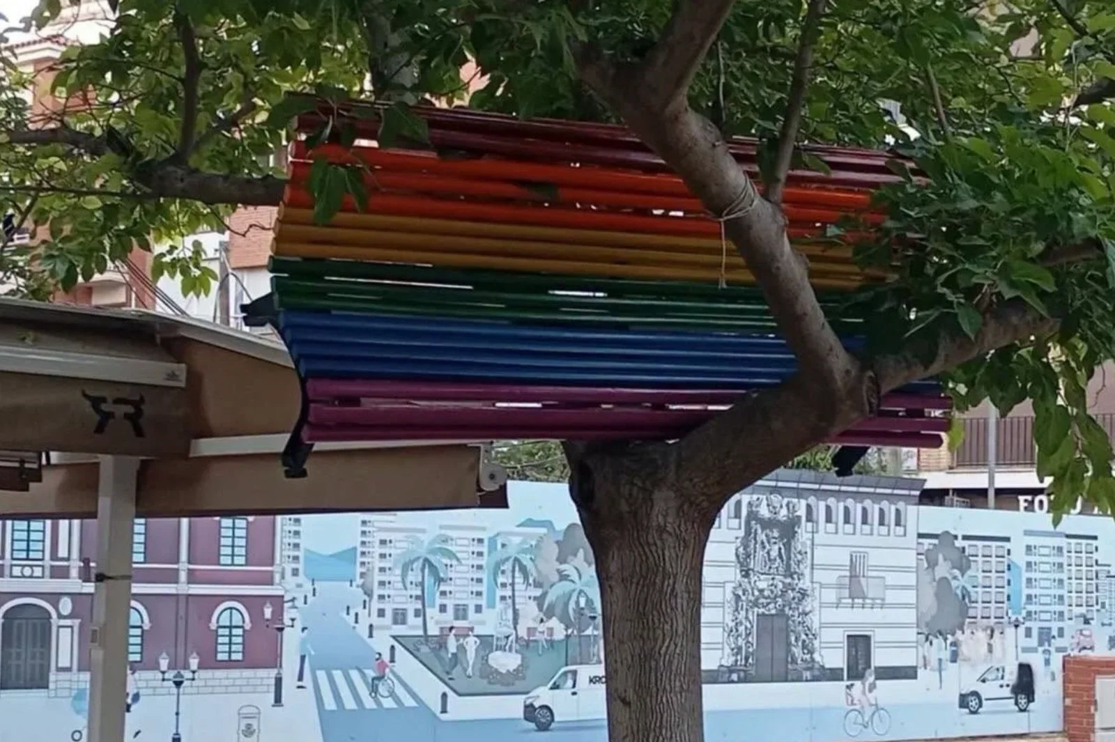 Encuentran un banco arcoíris LGTBI en lo alto de un árbol en una plaza de Lorca